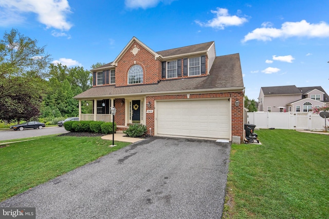 view of front facade featuring a front lawn, a garage, and a porch