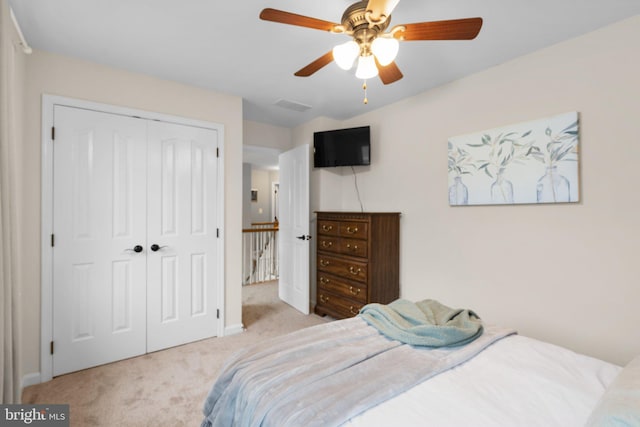 carpeted bedroom featuring a closet and ceiling fan