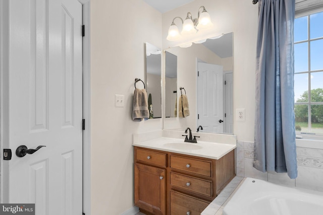 bathroom with a tub and vanity