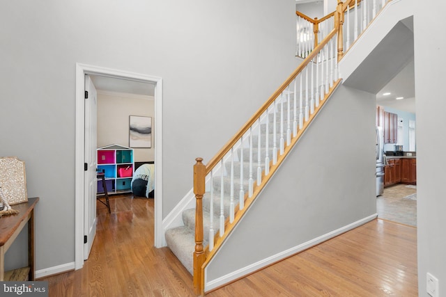 stairway featuring hardwood / wood-style flooring and ornamental molding