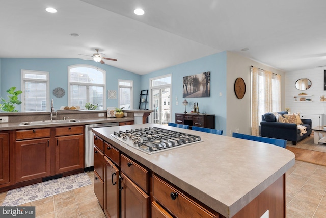 kitchen with vaulted ceiling, a center island, stainless steel appliances, sink, and ceiling fan