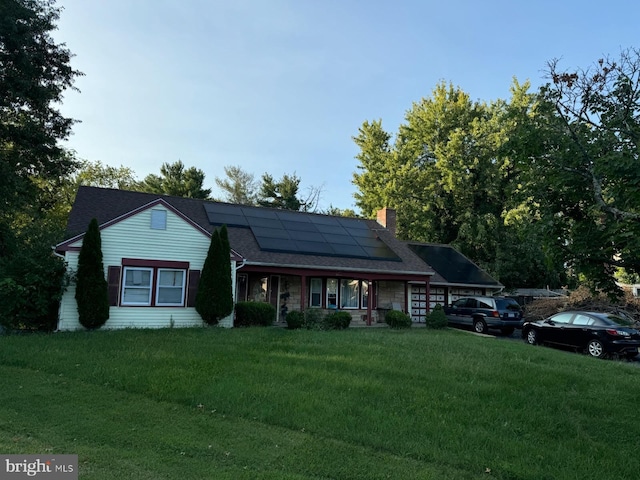 view of front facade featuring a front lawn and solar panels