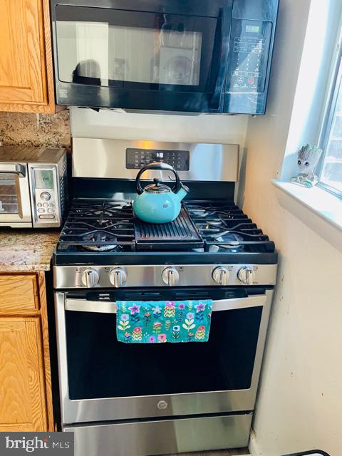 kitchen featuring gas stove and tasteful backsplash