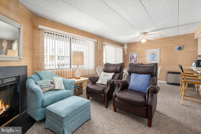 carpeted living room with a textured ceiling and ceiling fan