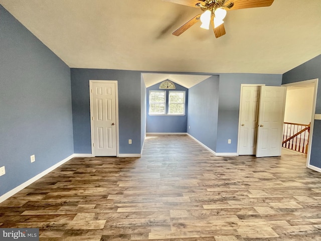 unfurnished room with baseboards, lofted ceiling, and wood finished floors