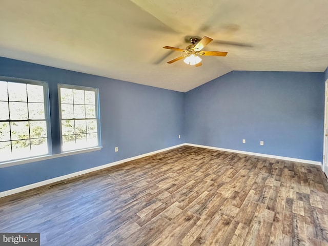 unfurnished room with lofted ceiling, wood finished floors, visible vents, and baseboards