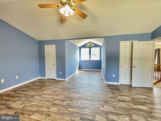 interior space featuring vaulted ceiling, wood finished floors, baseboards, and ceiling fan