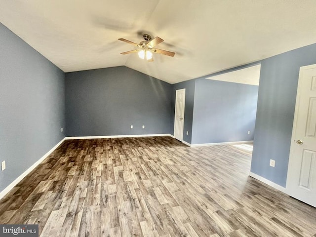 unfurnished room with ceiling fan, baseboards, lofted ceiling, and wood finished floors