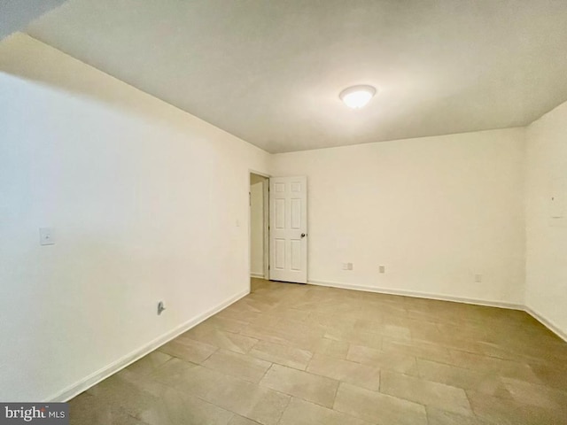 unfurnished room with baseboards