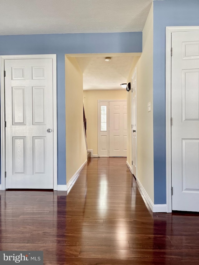 foyer entrance featuring baseboards and wood finished floors