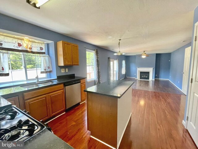 kitchen featuring dark hardwood / wood-style floors, sink, stainless steel appliances, hanging light fixtures, and a center island