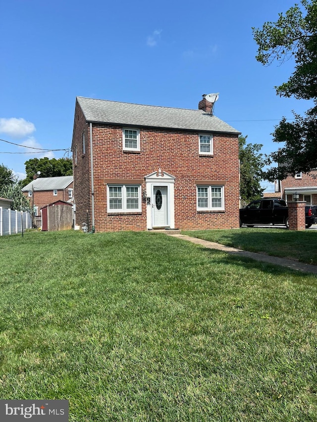 rear view of property with a yard and a shed