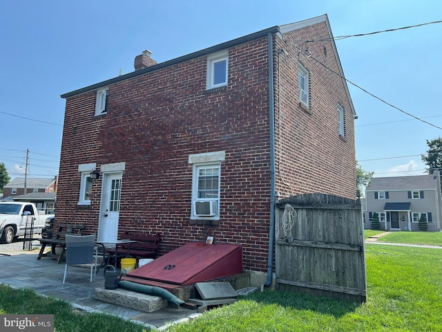 back of property with cooling unit and a yard