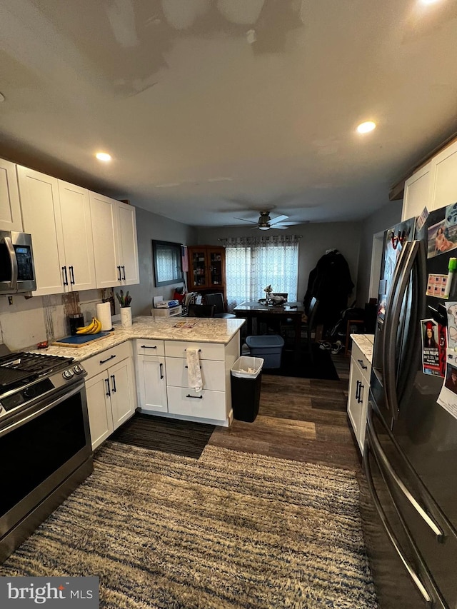 kitchen featuring kitchen peninsula, appliances with stainless steel finishes, ceiling fan, and white cabinets