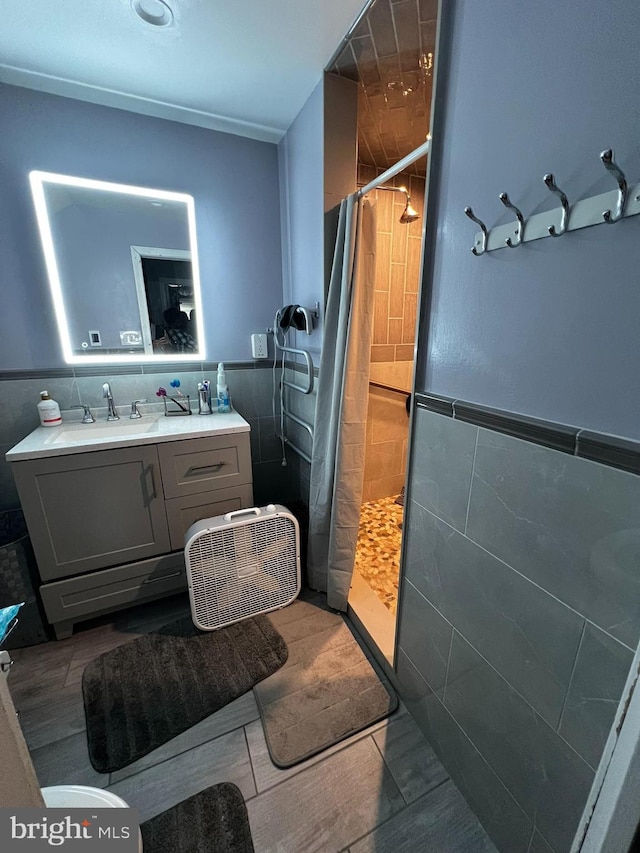 bathroom with a shower with shower curtain, vanity, and tile walls