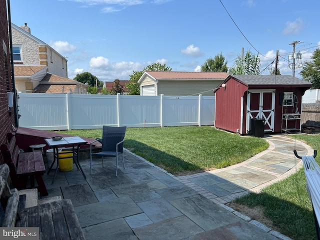 view of yard featuring a storage shed and a patio area