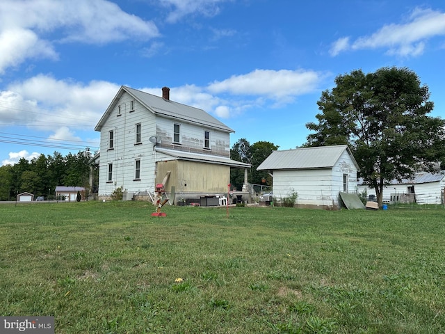 back of property with a lawn and a storage shed