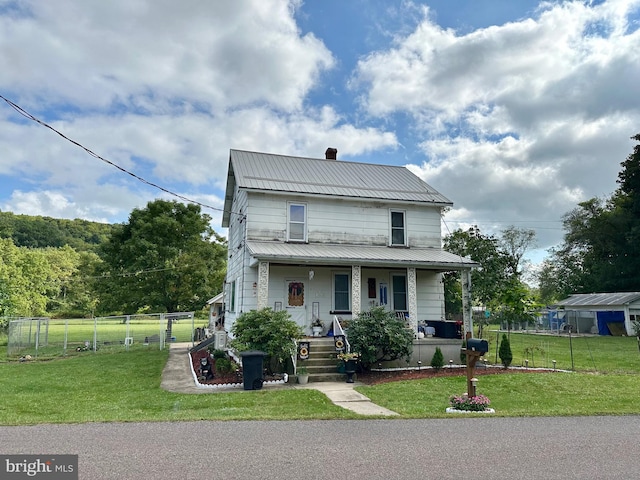 view of front facade with a storage unit, a front yard, and a porch