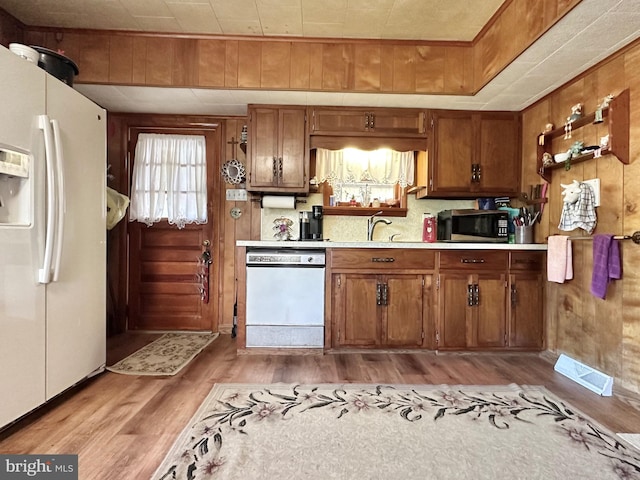 kitchen featuring light wood-type flooring, white appliances, and sink