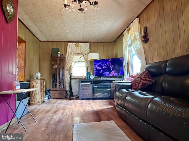 living room featuring plenty of natural light, wood-type flooring, and wooden walls