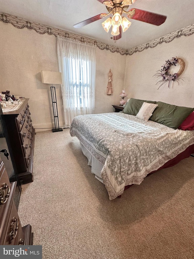 carpeted bedroom with a textured ceiling and ceiling fan