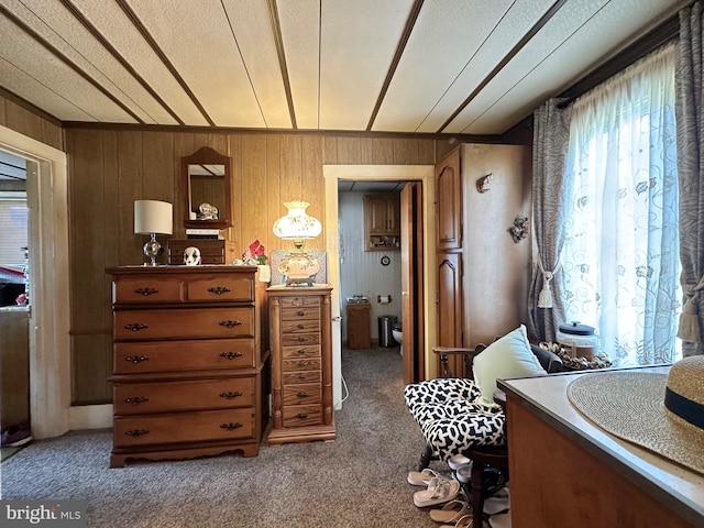 bedroom featuring wood walls and carpet floors