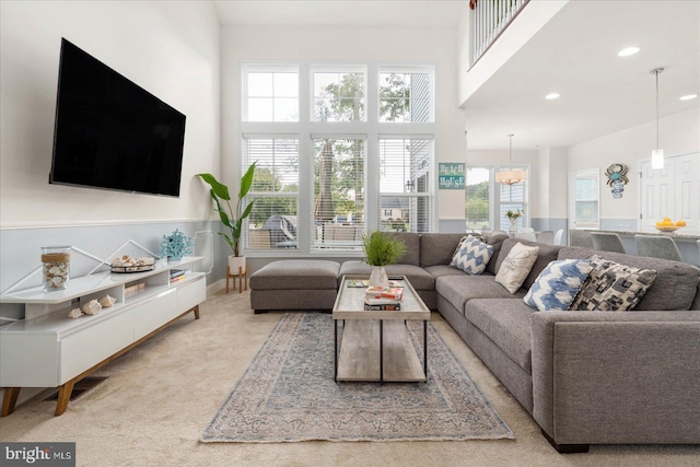 carpeted living area with a high ceiling and recessed lighting