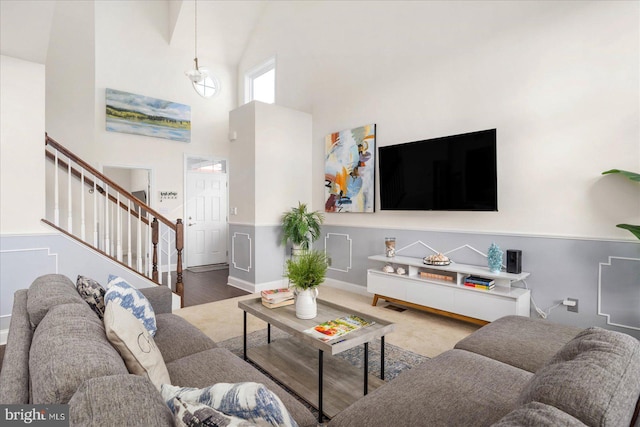 living room featuring a towering ceiling and hardwood / wood-style floors