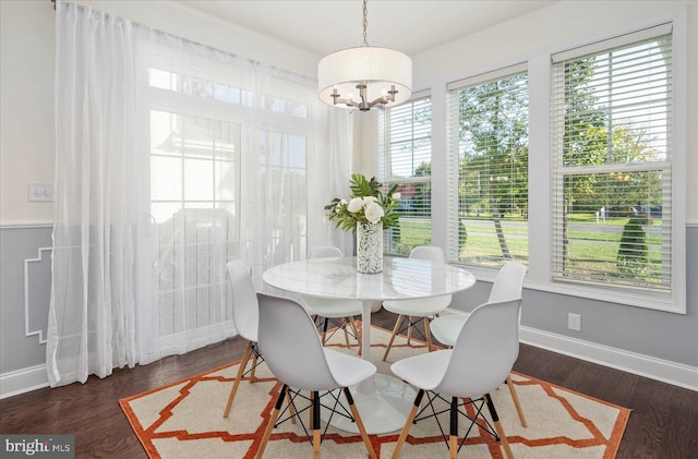 dining space featuring a healthy amount of sunlight, dark hardwood / wood-style floors, and a notable chandelier