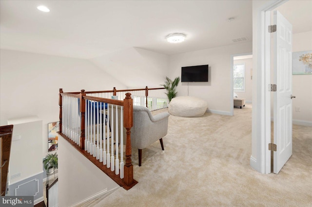 corridor with lofted ceiling and light carpet