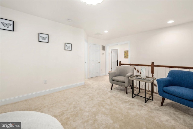 sitting room featuring light colored carpet