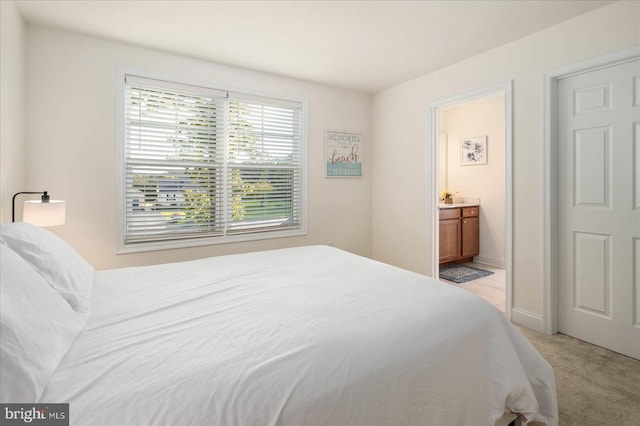 bedroom featuring light colored carpet and connected bathroom