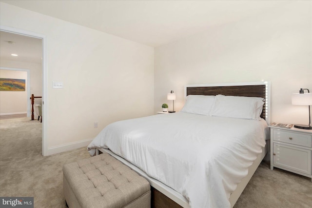 bedroom featuring light carpet and baseboards