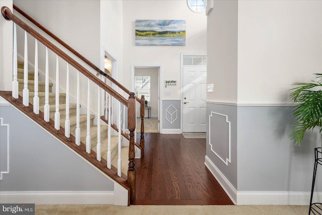 foyer with a high ceiling, stairway, and baseboards