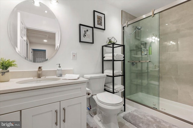 bathroom featuring vanity, a shower stall, and toilet