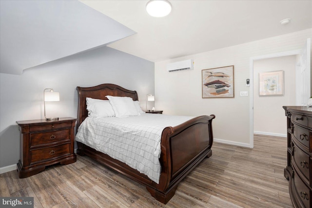 bedroom featuring a wall mounted AC and hardwood / wood-style flooring