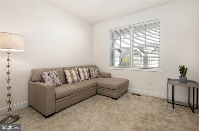 living area featuring baseboards, visible vents, and carpet flooring