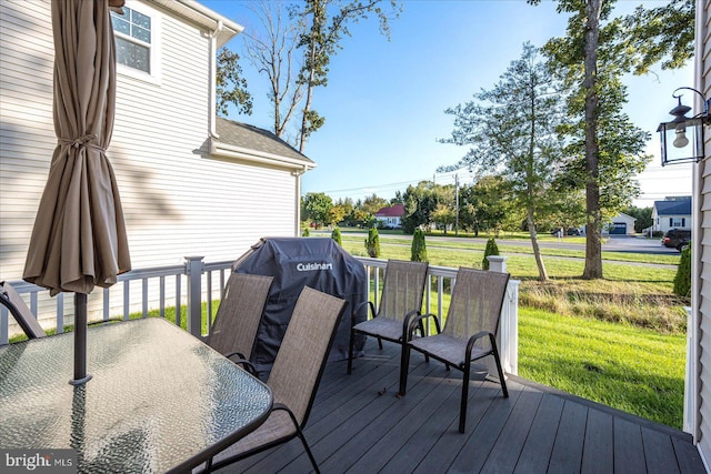 wooden deck with outdoor dining space and a lawn