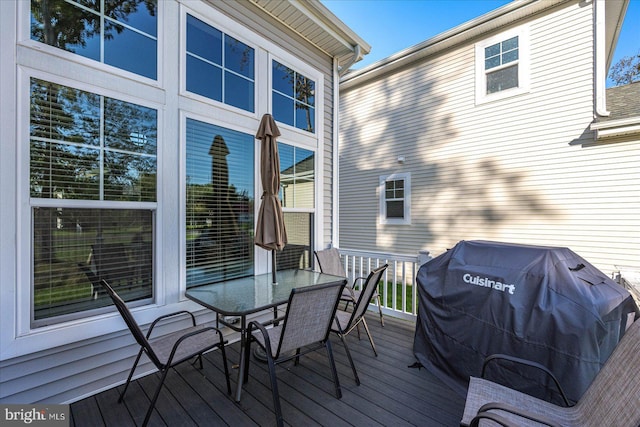 wooden deck with outdoor dining area and a grill