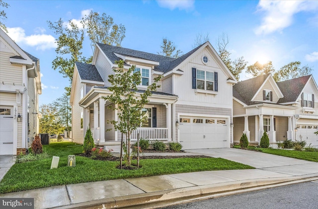 view of front of home with a garage, a front yard, and covered porch