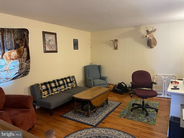 living room with wood-type flooring and a textured ceiling