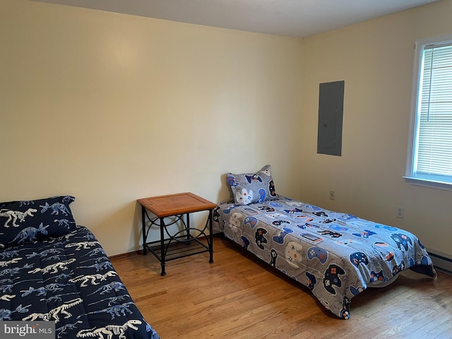 bedroom with light wood-type flooring and electric panel