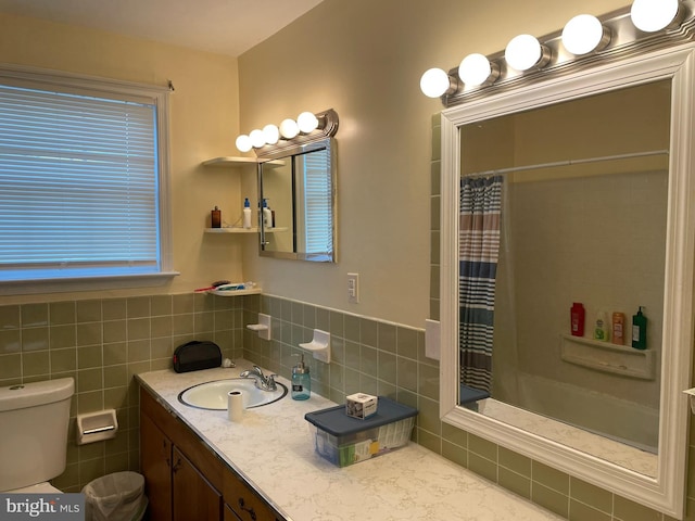 bathroom featuring vanity, toilet, a shower with shower curtain, and tile walls