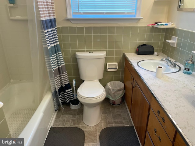 full bathroom with tile walls, toilet, shower / tub combo, and vanity