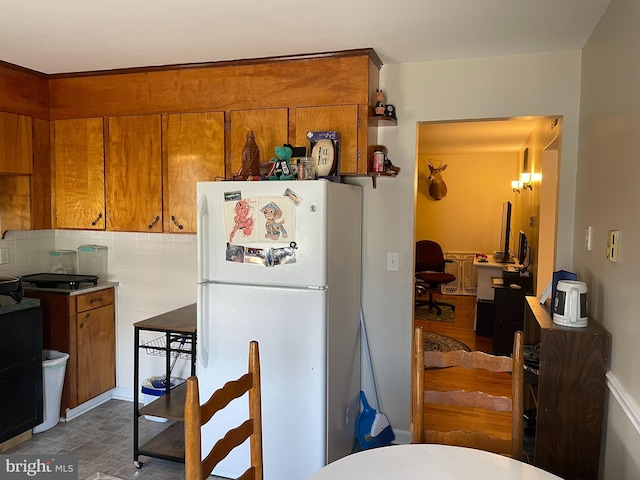 kitchen with white refrigerator and decorative backsplash