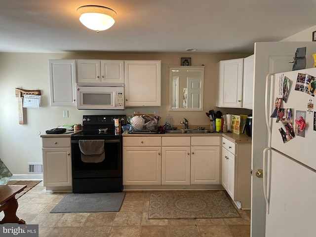 kitchen with sink, white appliances, and white cabinetry