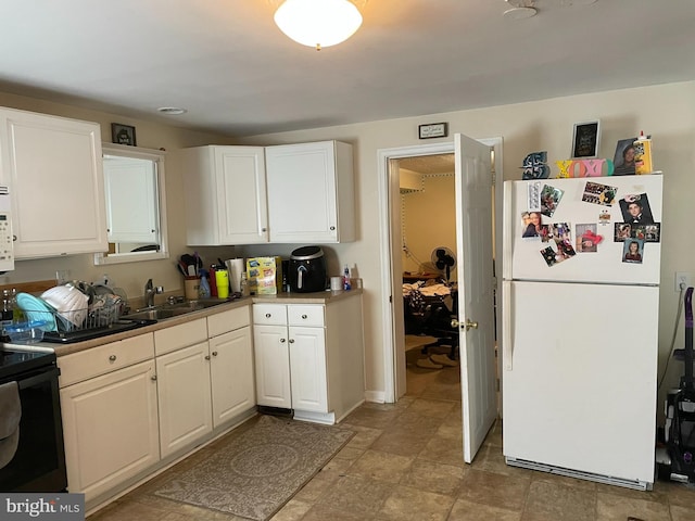 kitchen featuring sink, white appliances, and white cabinets