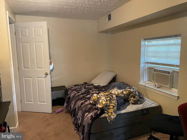 carpeted bedroom with a textured ceiling and cooling unit