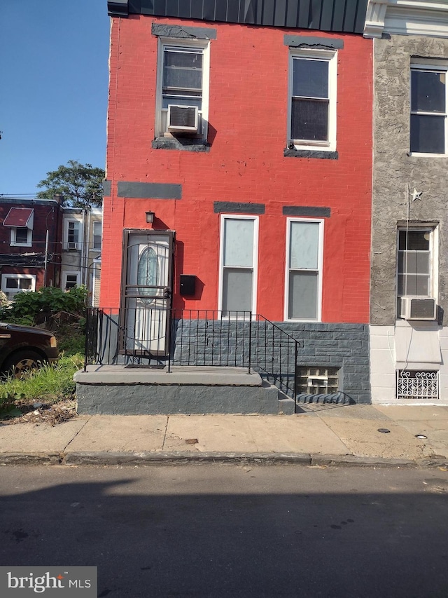 townhome / multi-family property featuring cooling unit and brick siding