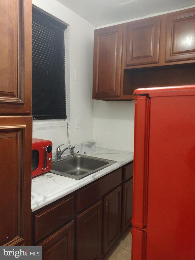 kitchen with light tile patterned floors and sink